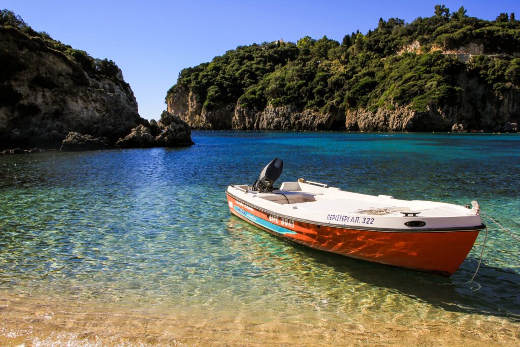 Ein Boot, das sanft auf den Wellen eines Strandes in Saranda, Albanien, schaukelt.