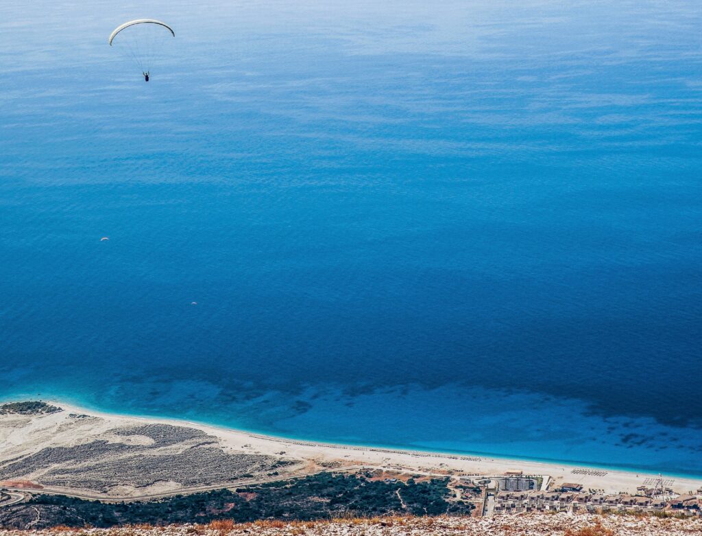 Paragliding über der Küstenlandschaft von Palase aus der Vogelperspektive.