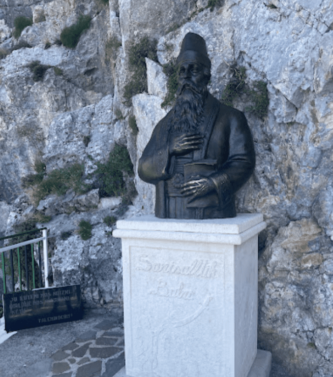 Die beeindruckende Statue von Sari Salltik wacht über die historische Bektaschi Tekke in Kruja, Albanien. Erkunden Sie diese bedeutende religiöse Stätte des Sufismus und erfahren Sie mehr über die faszinierende Geschichte des Bektaschi-Ordens.